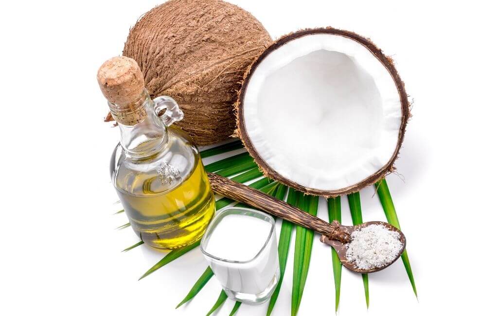 Kokos, kokosovo ulje i kašičica s uljem na palmi